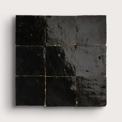 Nine black square zellige tiles arranged in a 3x3 grid on a white background