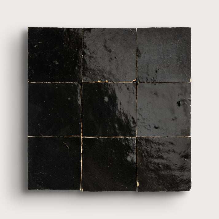 Nine black square zellige tiles arranged in a 3x3 grid on a white background