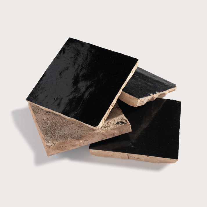 Black zellige tiles on a light gray background