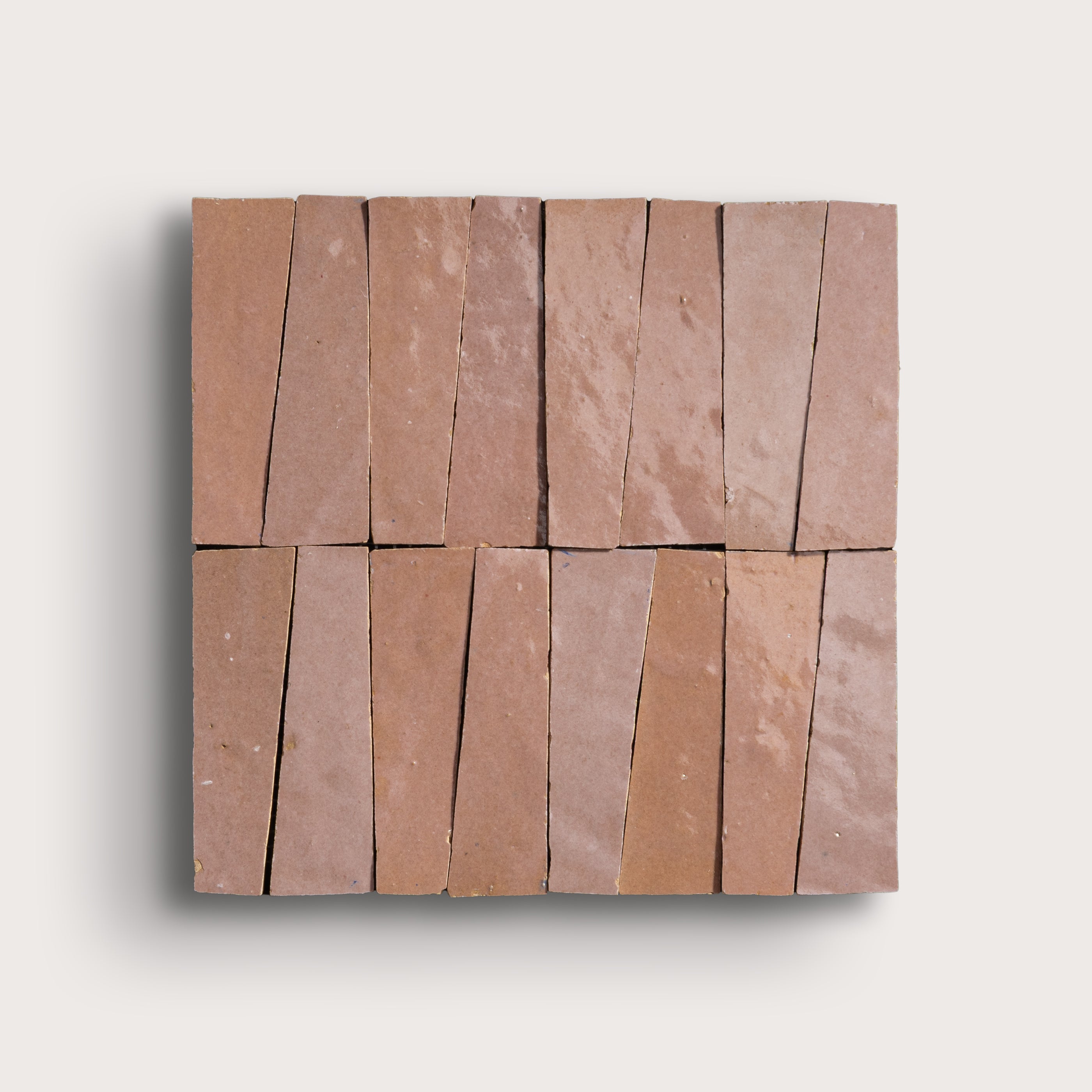 Zellige trapezoid tile with wavy blush pattern on a light gray background