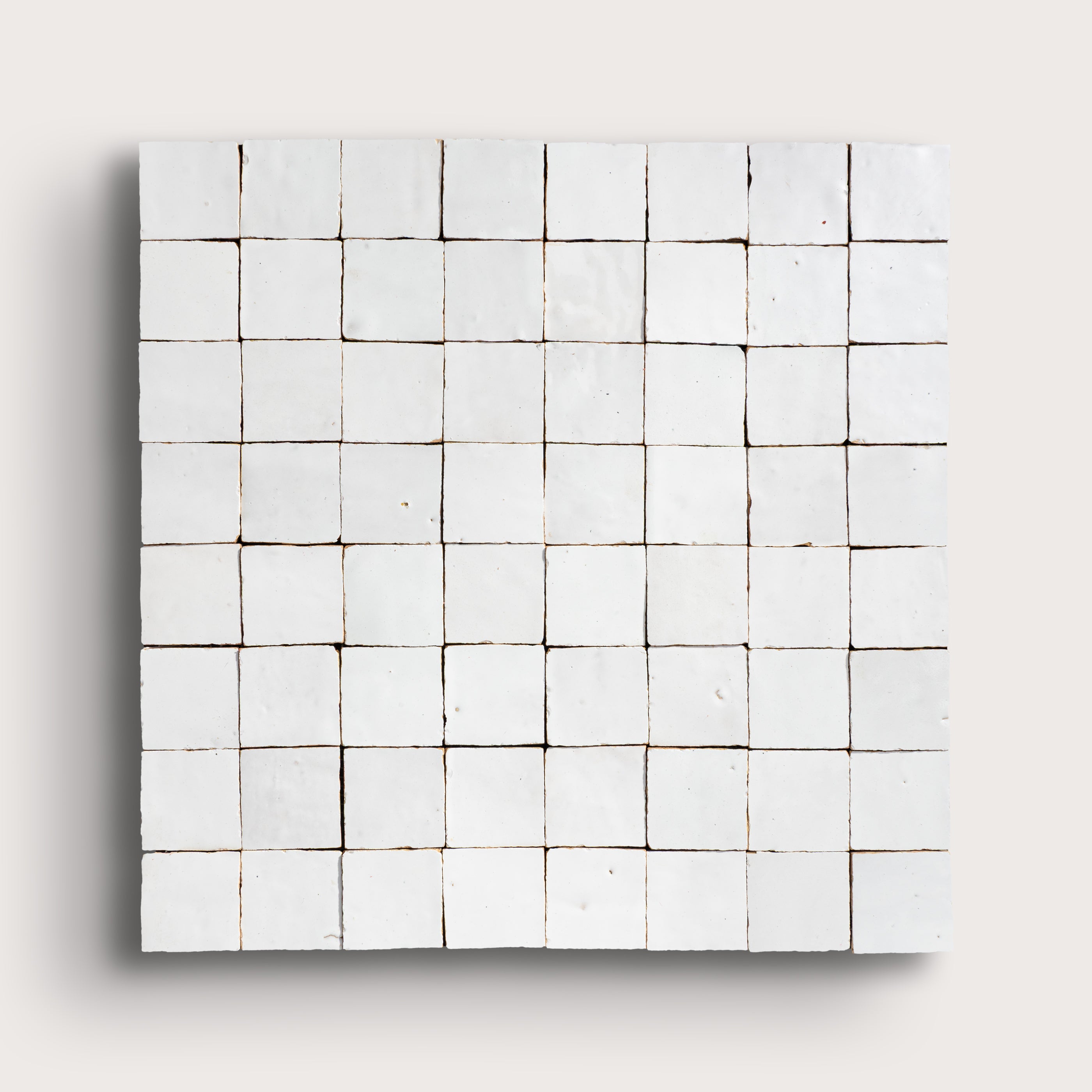 Grid of small white zellige tiles on a light gray background