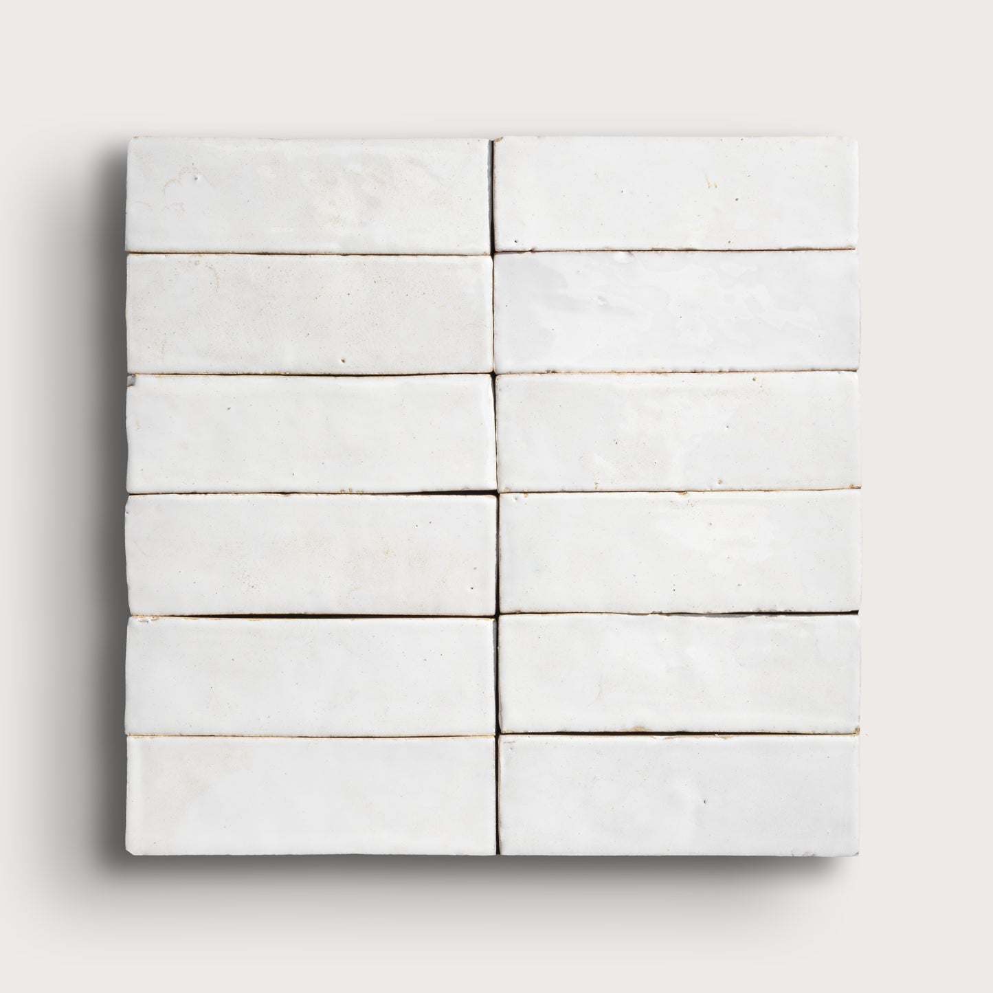 Set of white zellige tiles arranged in a grid pattern on a light gray background