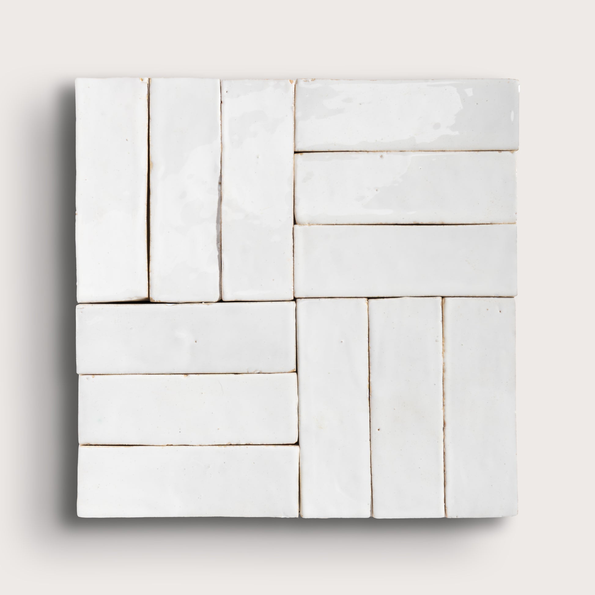 White zellige tiles arranged in a geometric pattern on a light gray background