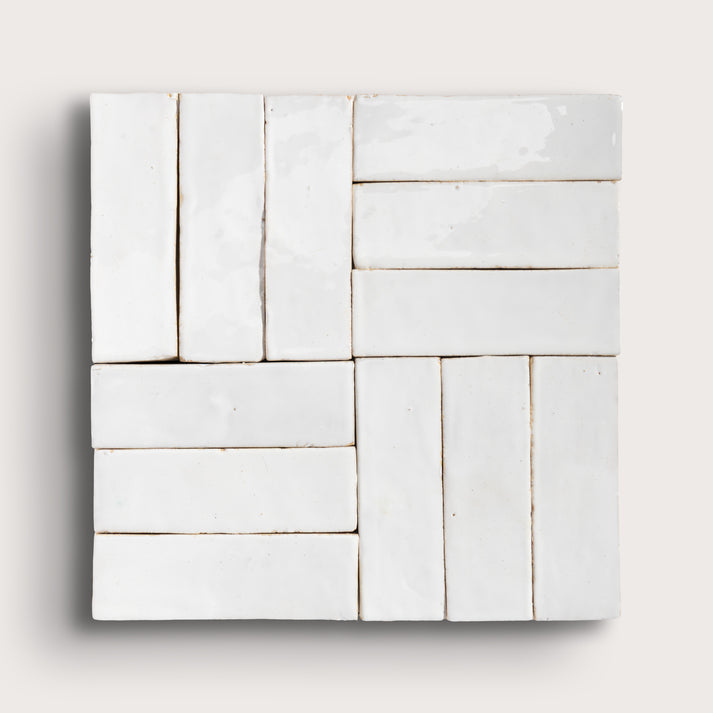 White zellige tiles arranged in a geometric pattern on a light gray background