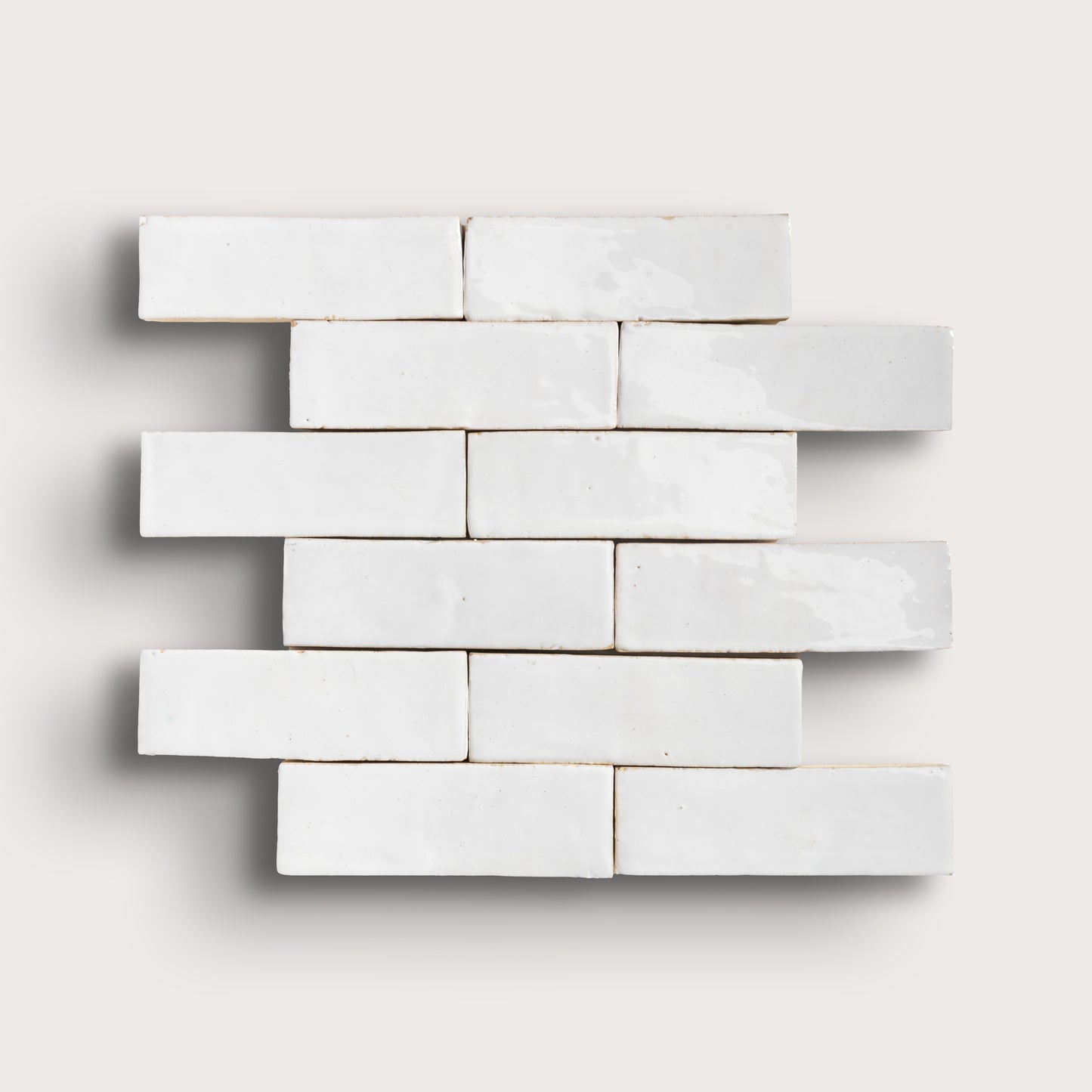 White zellige tiles arranged in a brick pattern on a light gray background