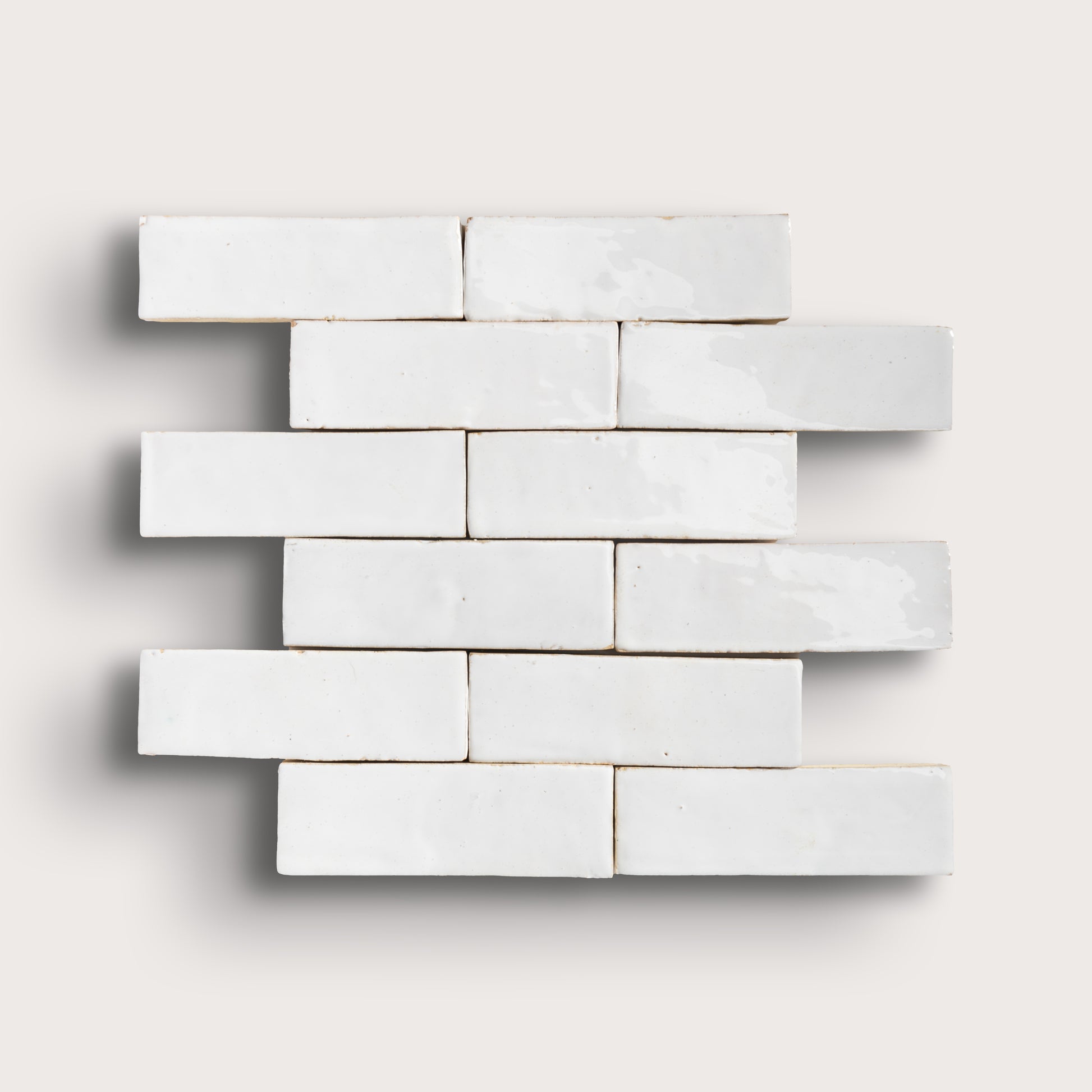 White zellige tiles arranged in a brick pattern on a light gray background