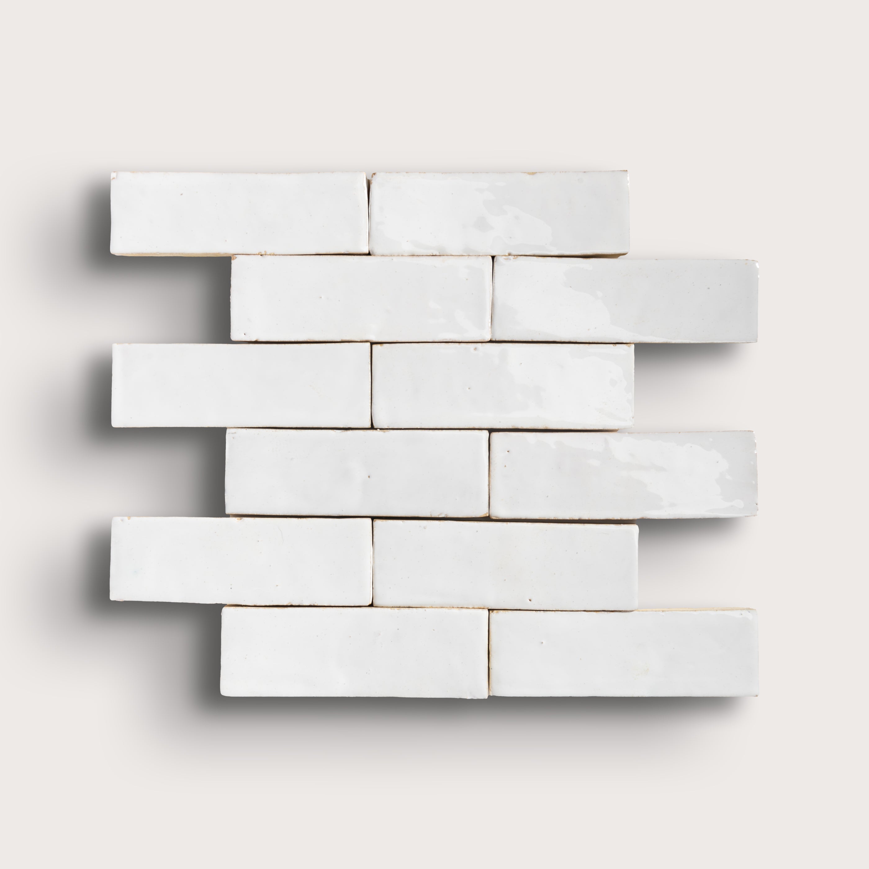 White zellige tiles arranged in a brick pattern on a light gray background