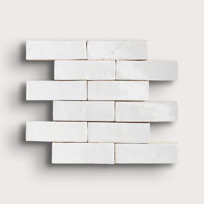 White zellige tiles arranged in a brick pattern on a light gray background