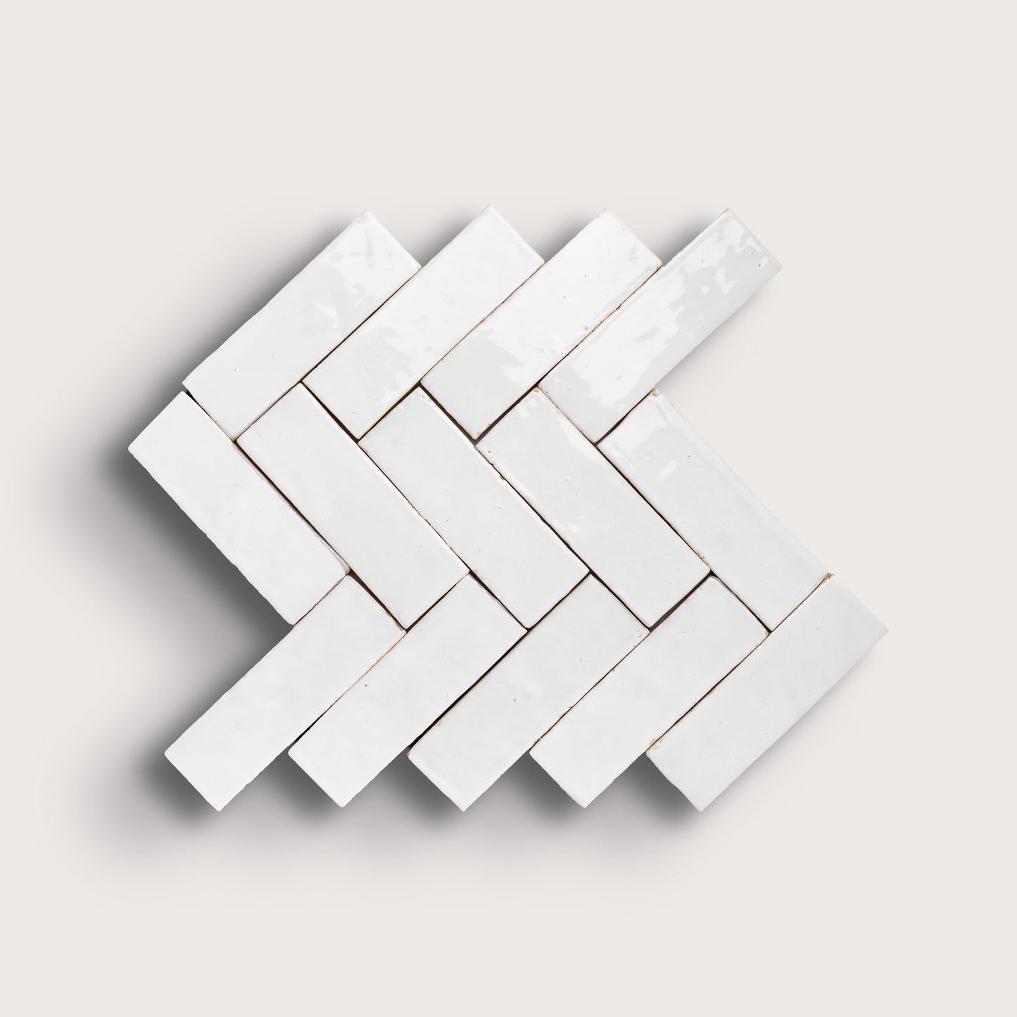 White herringbone mosaic tile pattern on a light gray background