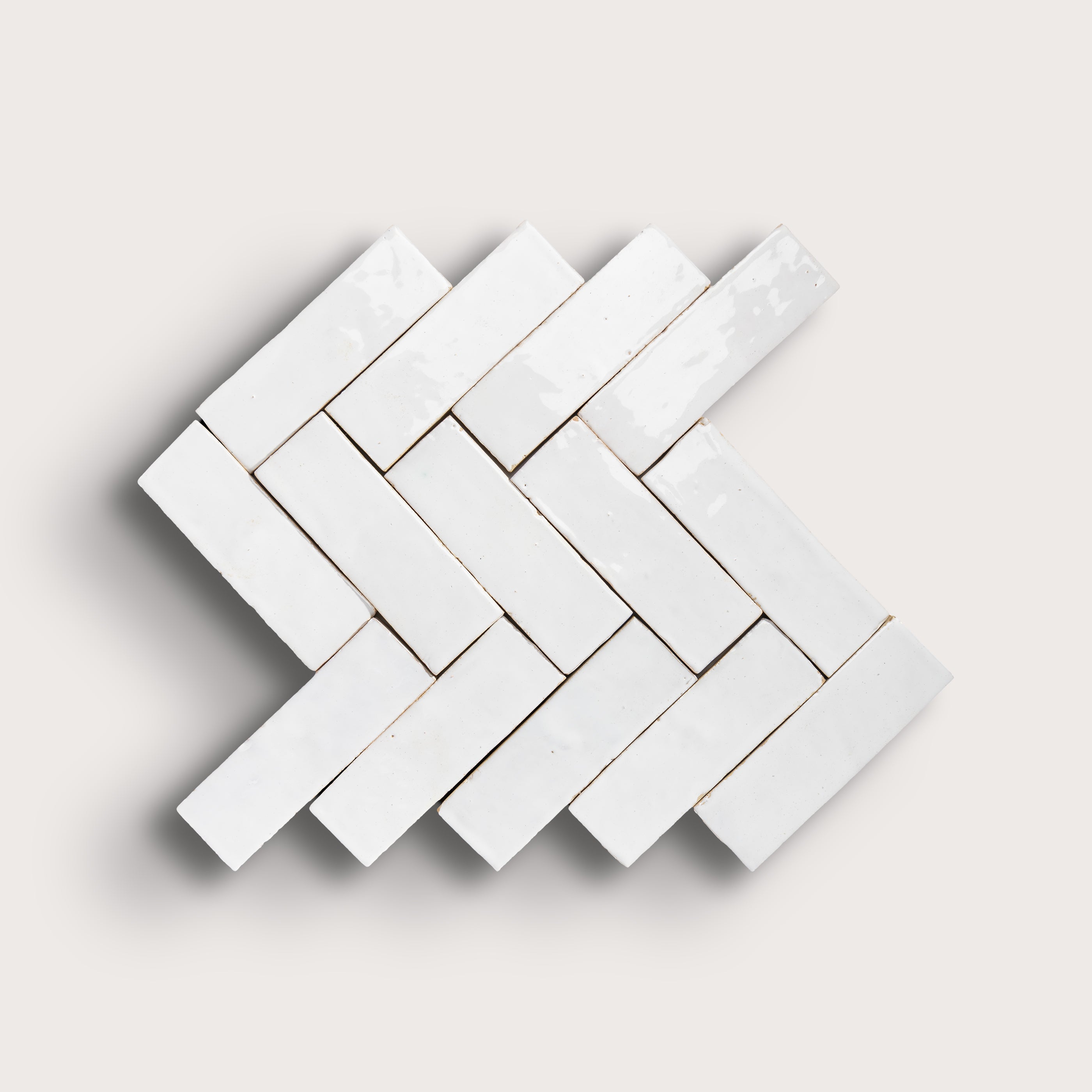 White herringbone mosaic tile pattern on a light gray background