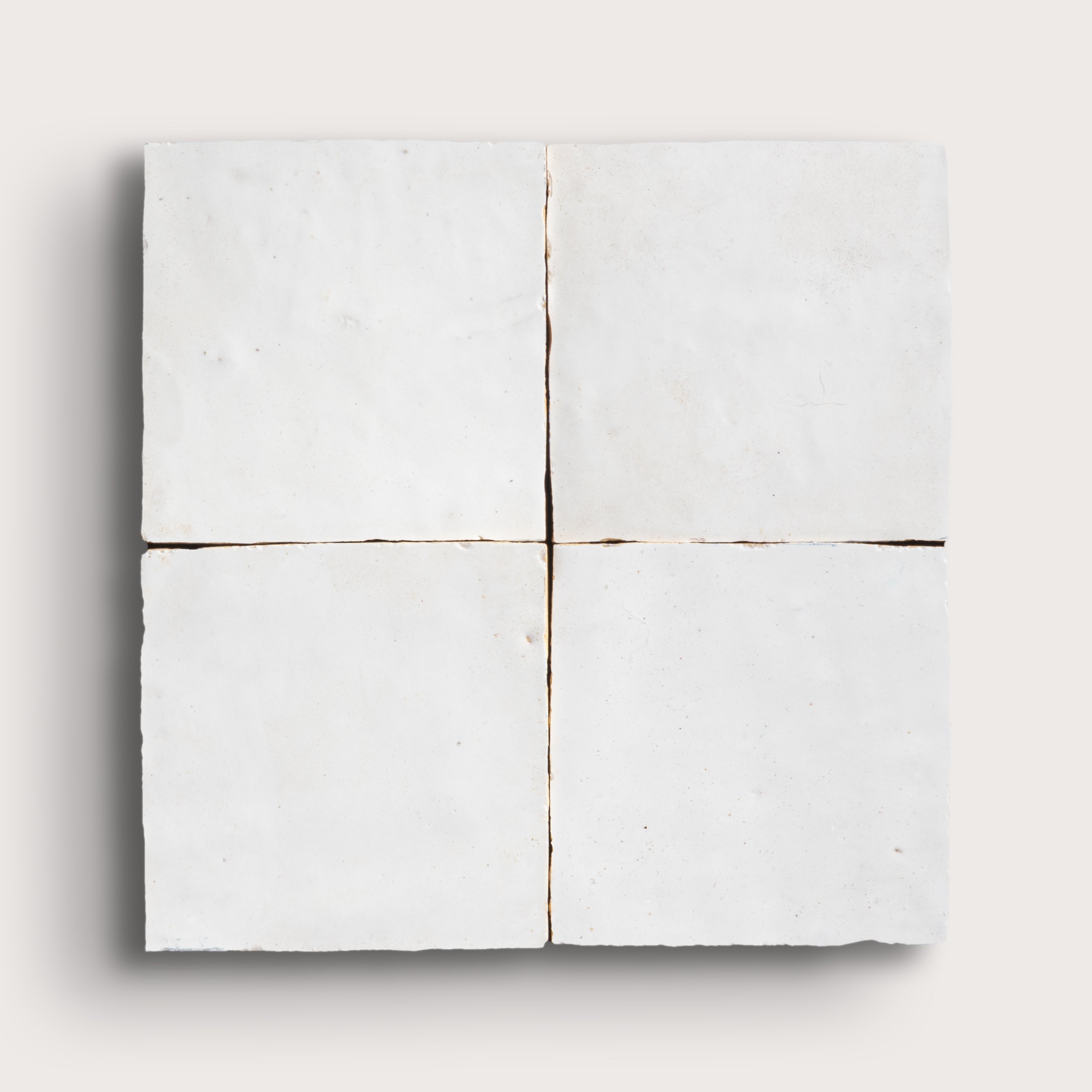 White zellige tile with a grid pattern on a white background