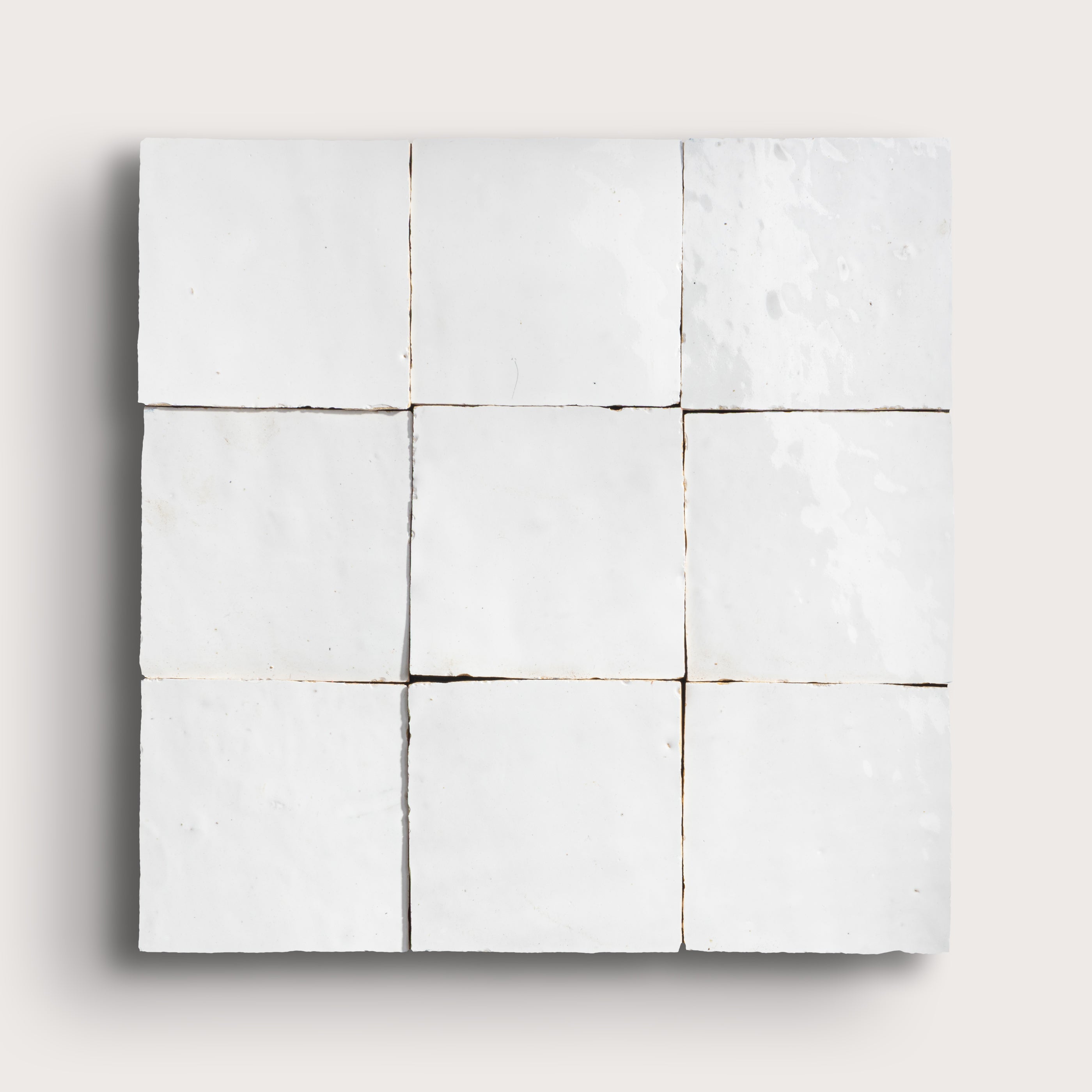 White zellige tile with a grid pattern on a white background