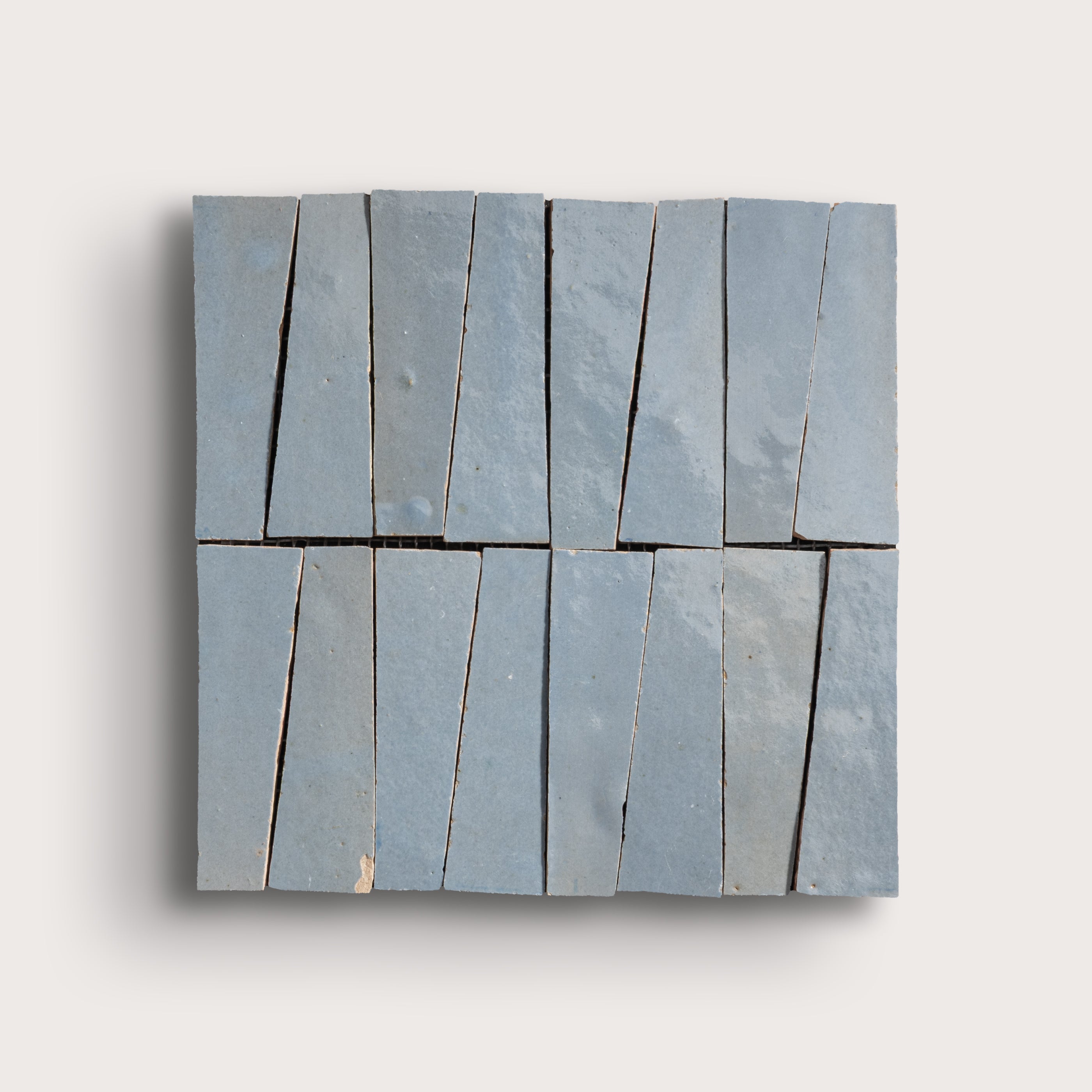 Rectangular blue zellige tile with a geometric pattern on a light gray background