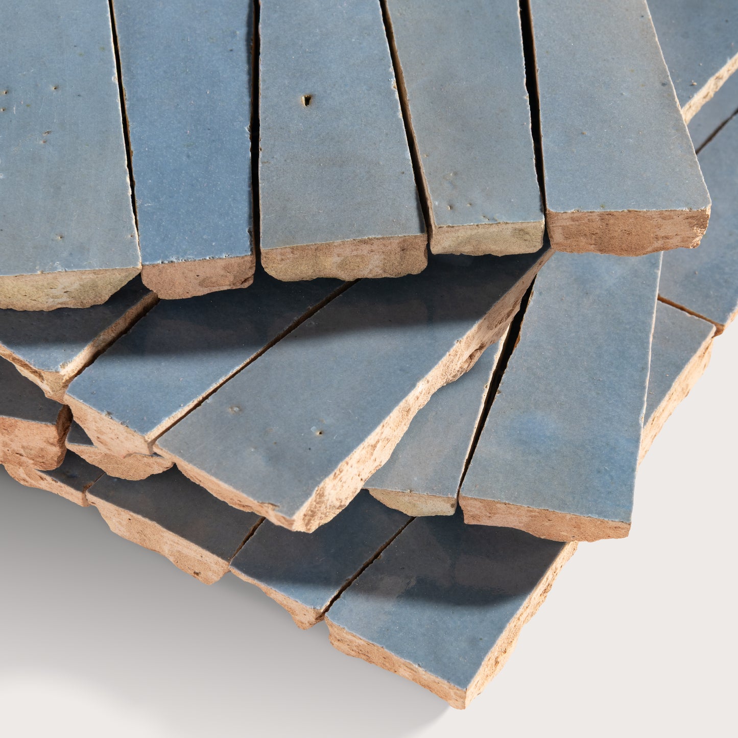 Stack of blue zellige tiles with a focus on texture and color variation.