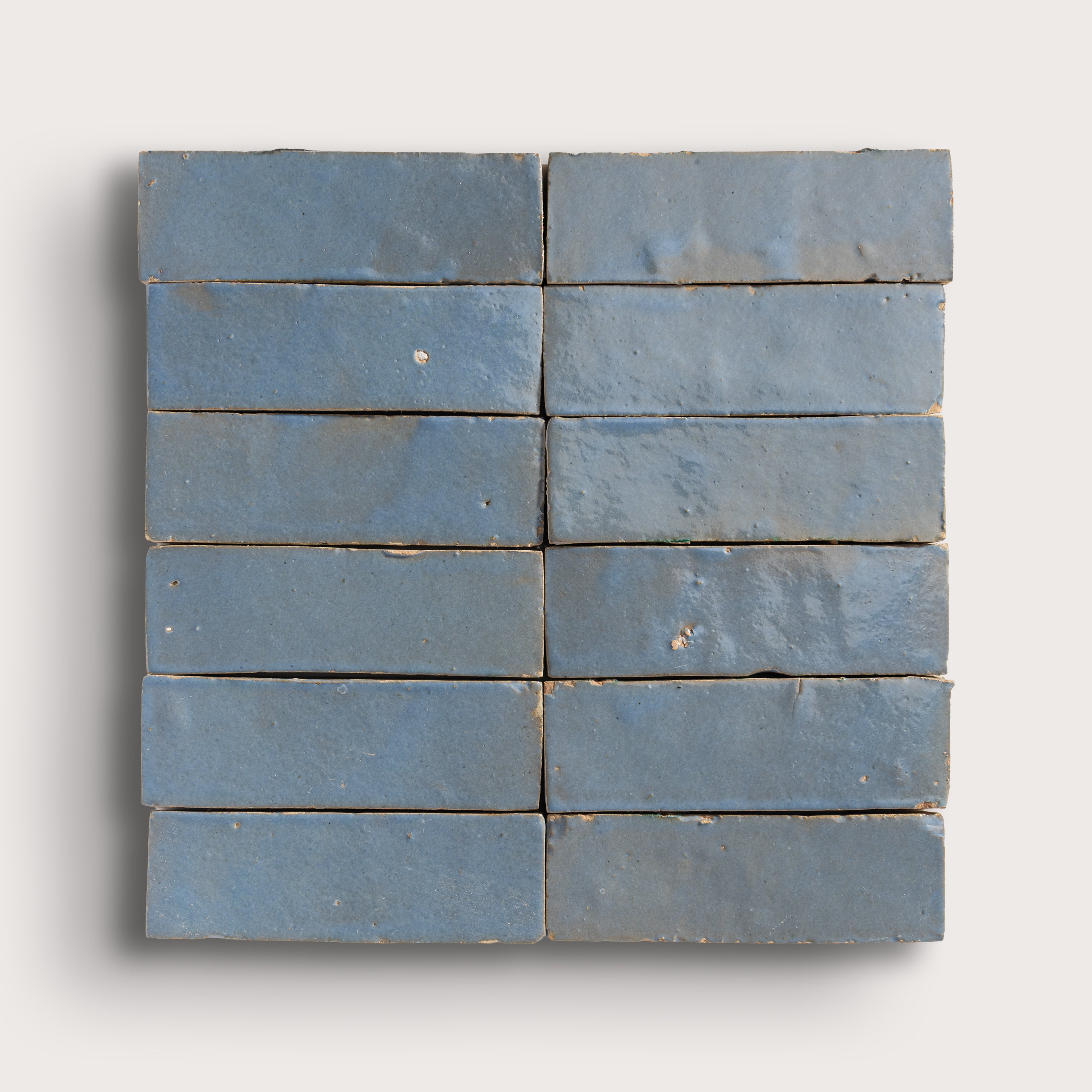 twelve blue rectangular zellige tiles arranged in a grid on a white background