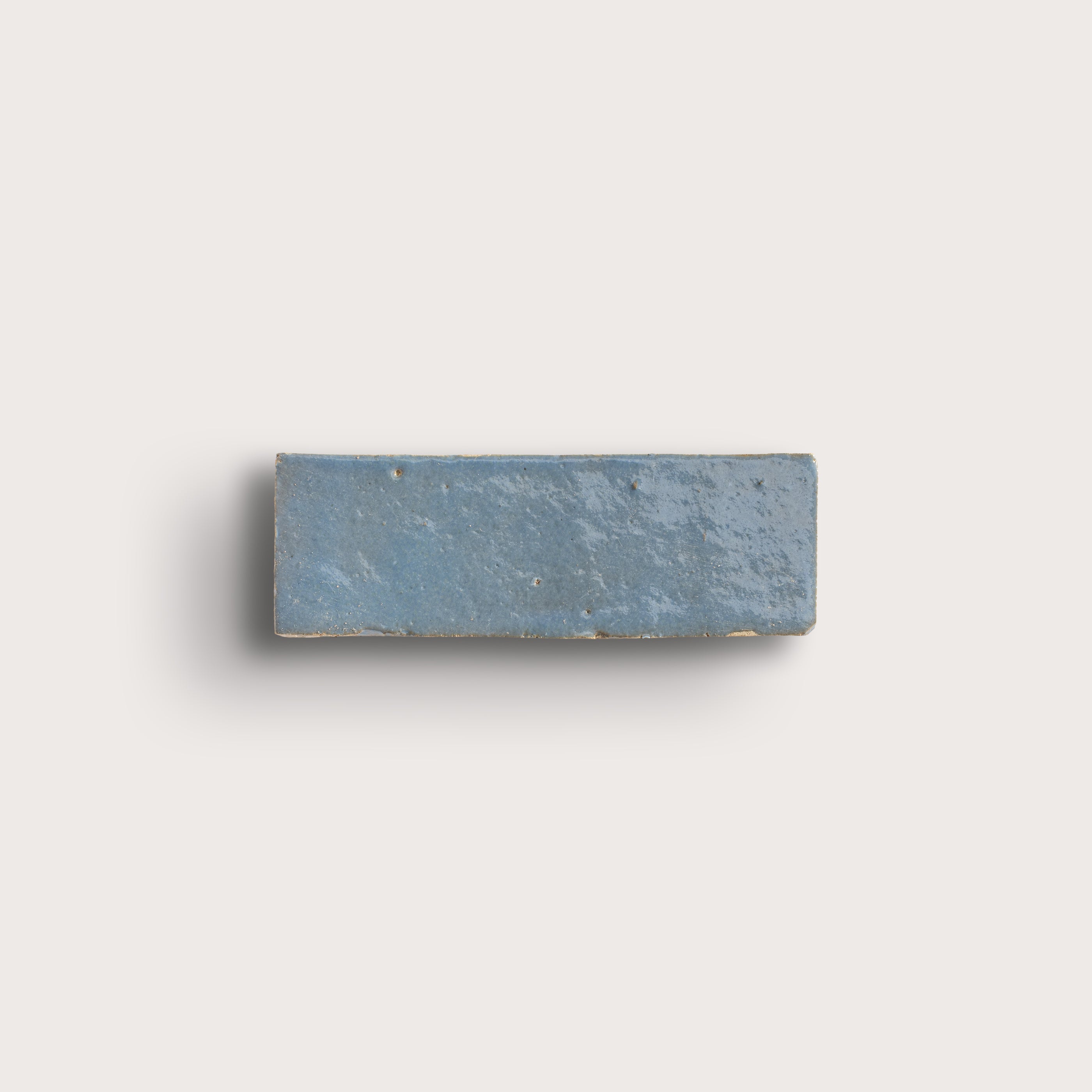 Rectangular blue stone zellige tile on a light gray background