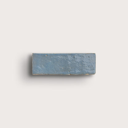 Rectangular blue stone zellige tile on a light gray background