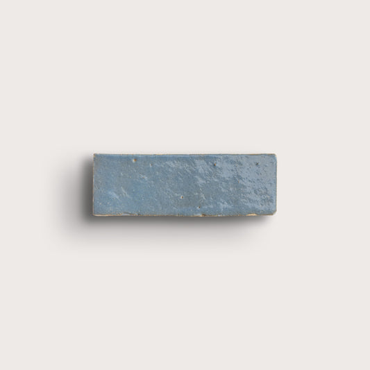 Rectangular blue stone zellige tile on a light gray background