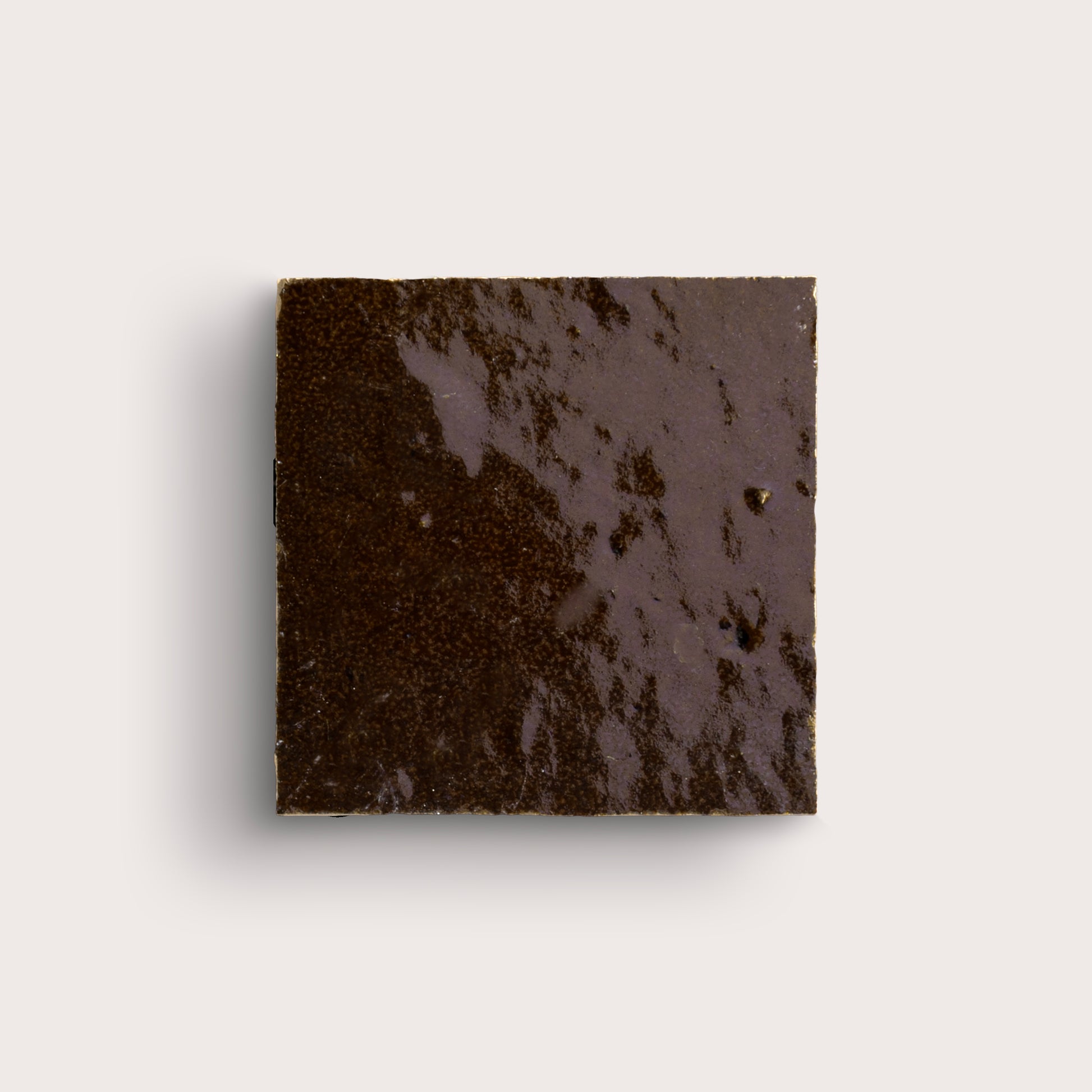 brown square zellige tile on a light grey background