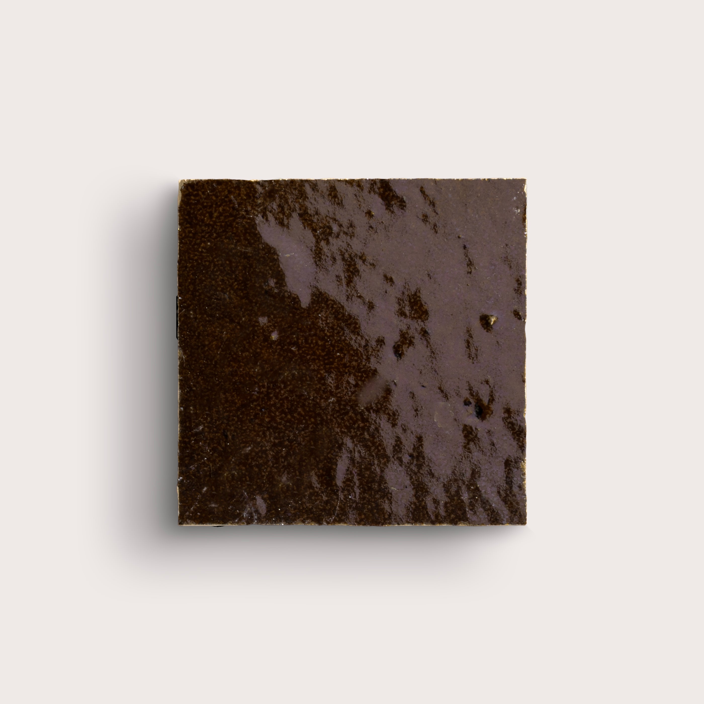 brown square zellige tile on a light grey background
