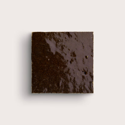 brown square zellige tile on a light grey background
