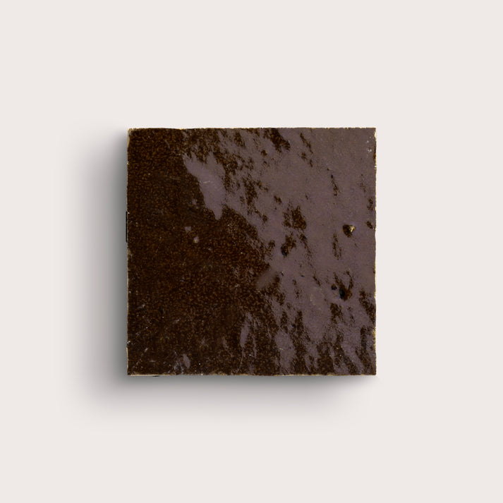brown square zellige tile on a light grey background