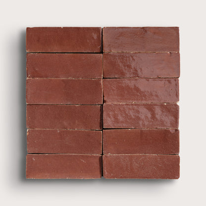 Nine red zellige tiles arranged in a 3x3 grid on a white background