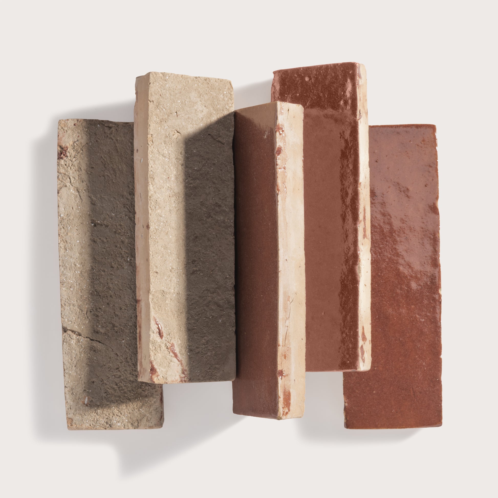 Five rectangular zellige tiles of different colors arranged on a white background