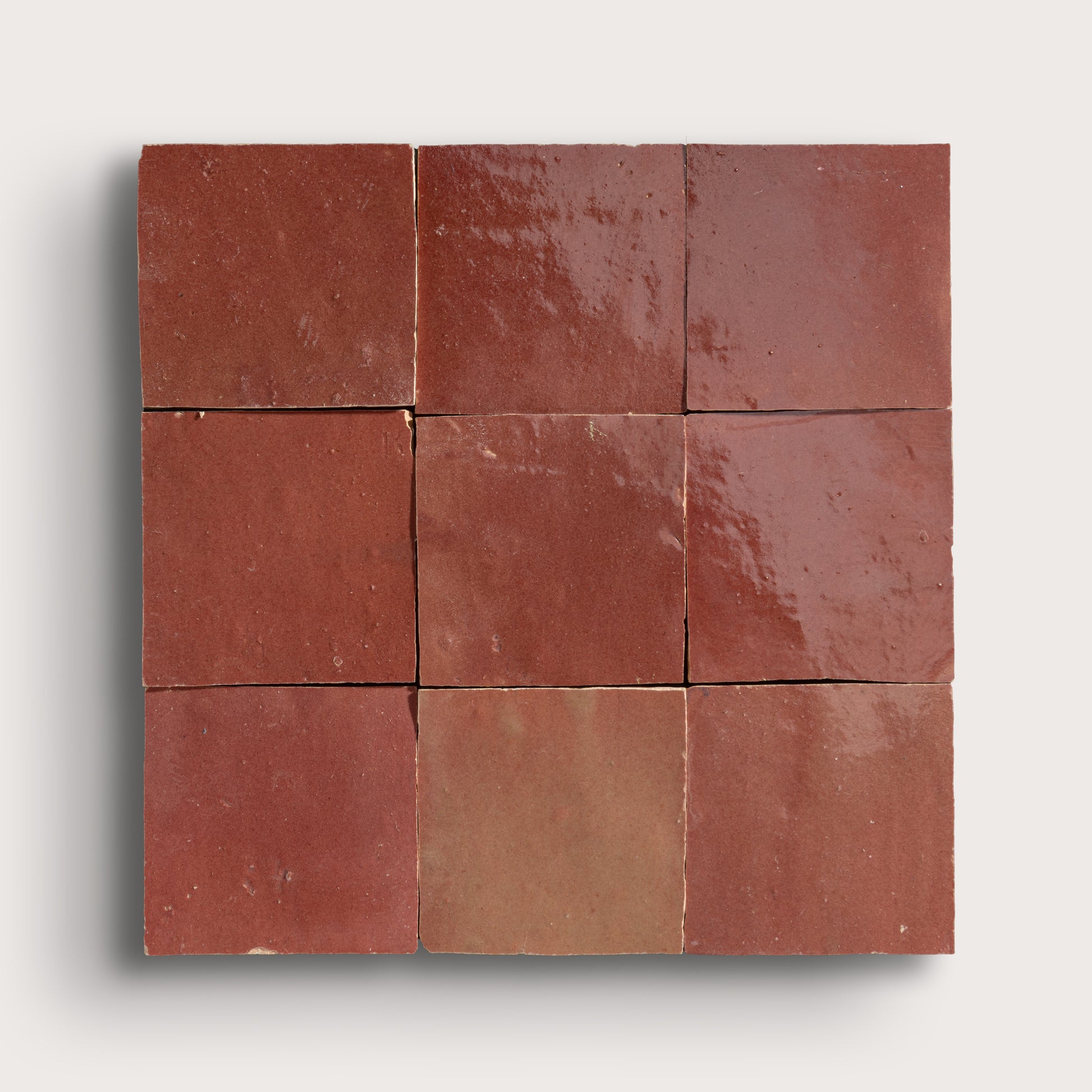 Nine square red zellige tile arranged in a 3x3 grid on a white background