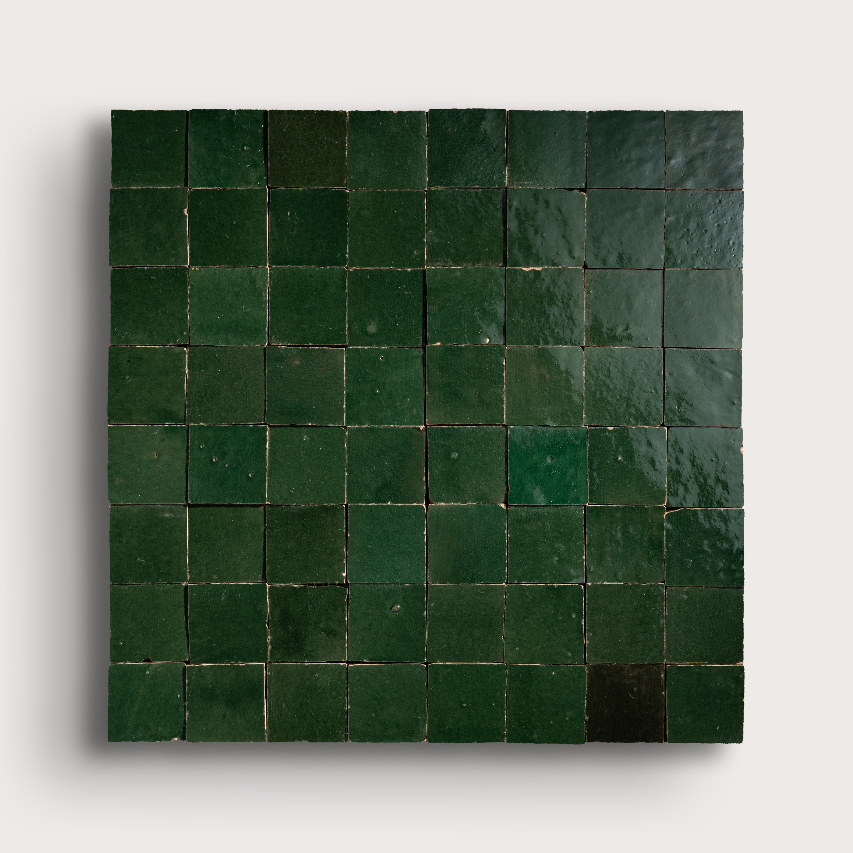 Square tile mosaic with green tiles on a white background