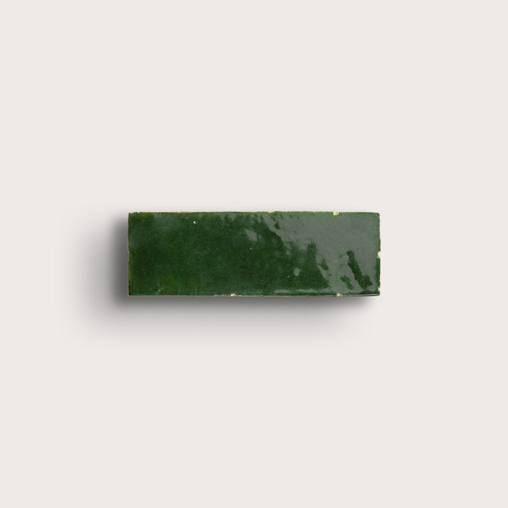 Rectangular green zellige tile on a light gray background