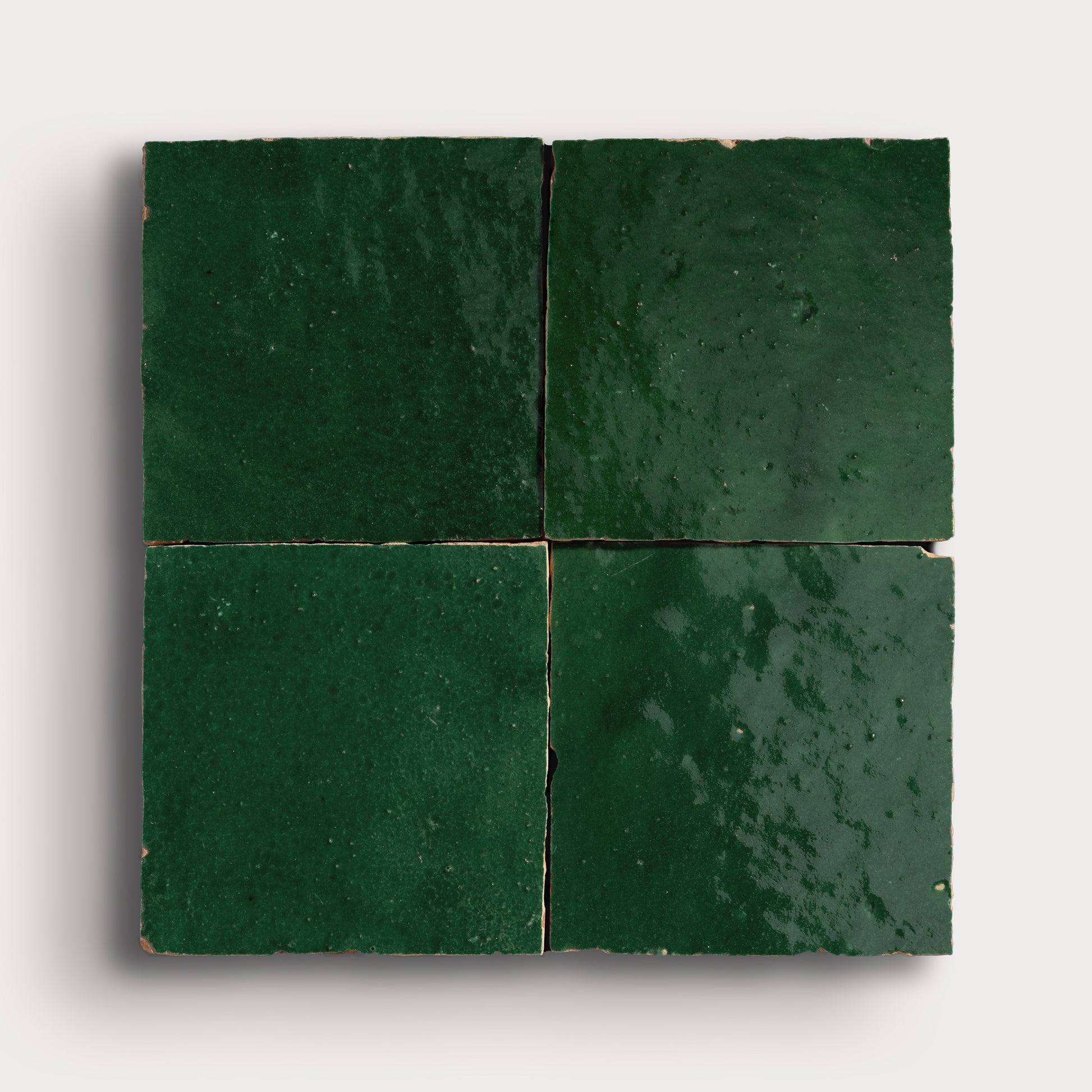 Four green zellige tiles arranged in a square pattern on a white background