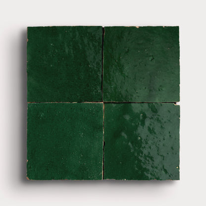 Four green zellige tiles arranged in a square pattern on a white background