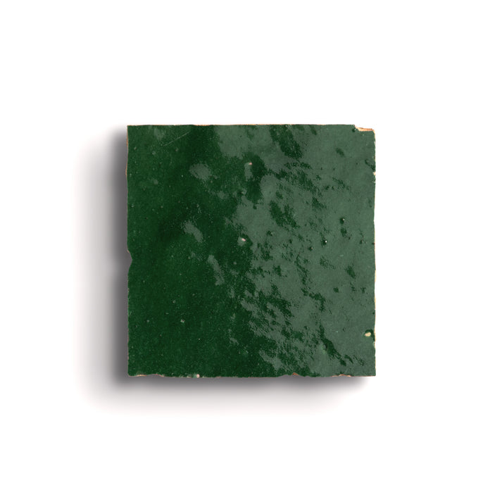 Square piece of green zellige tile on a white background