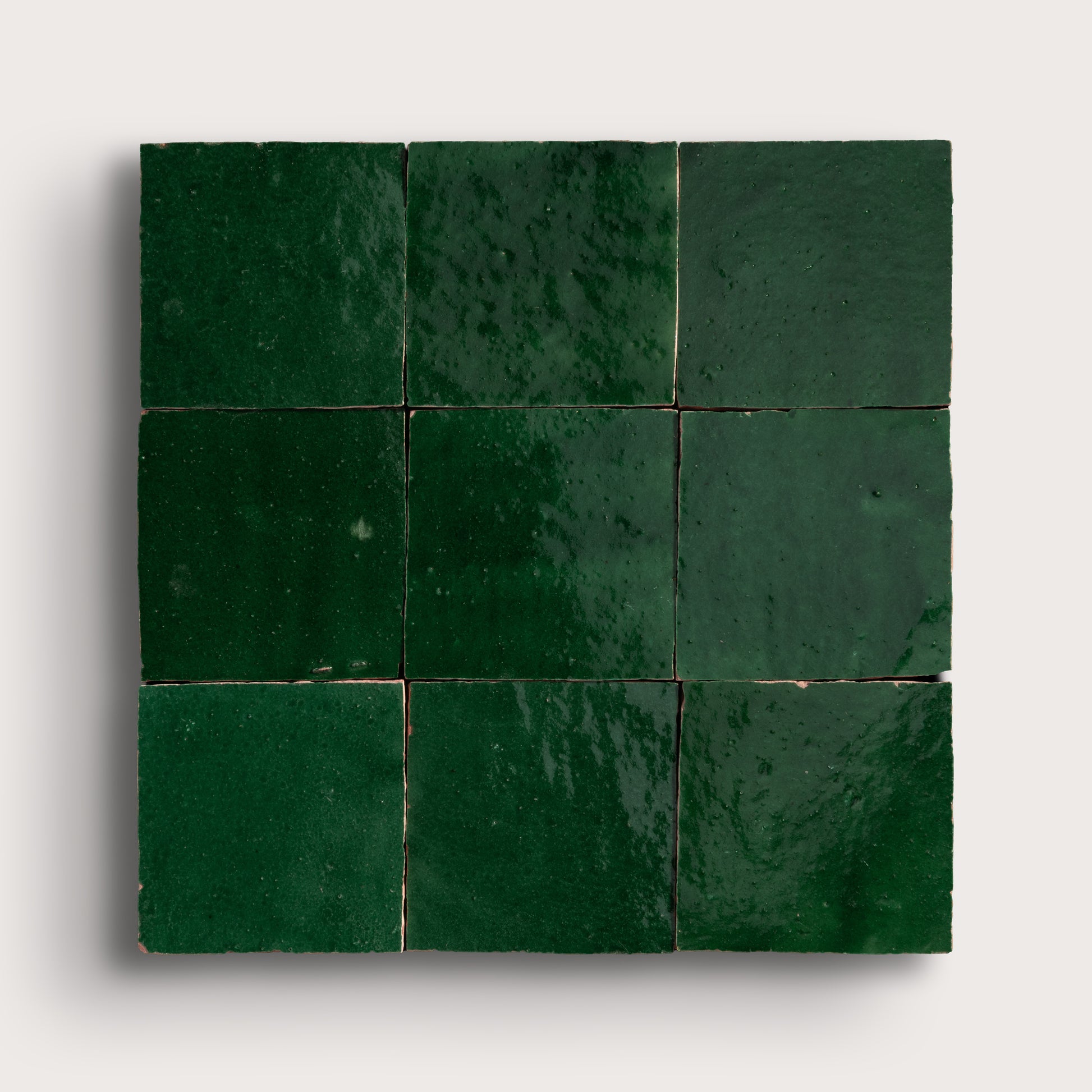 Square arrangement of green zellige tiles on a white background