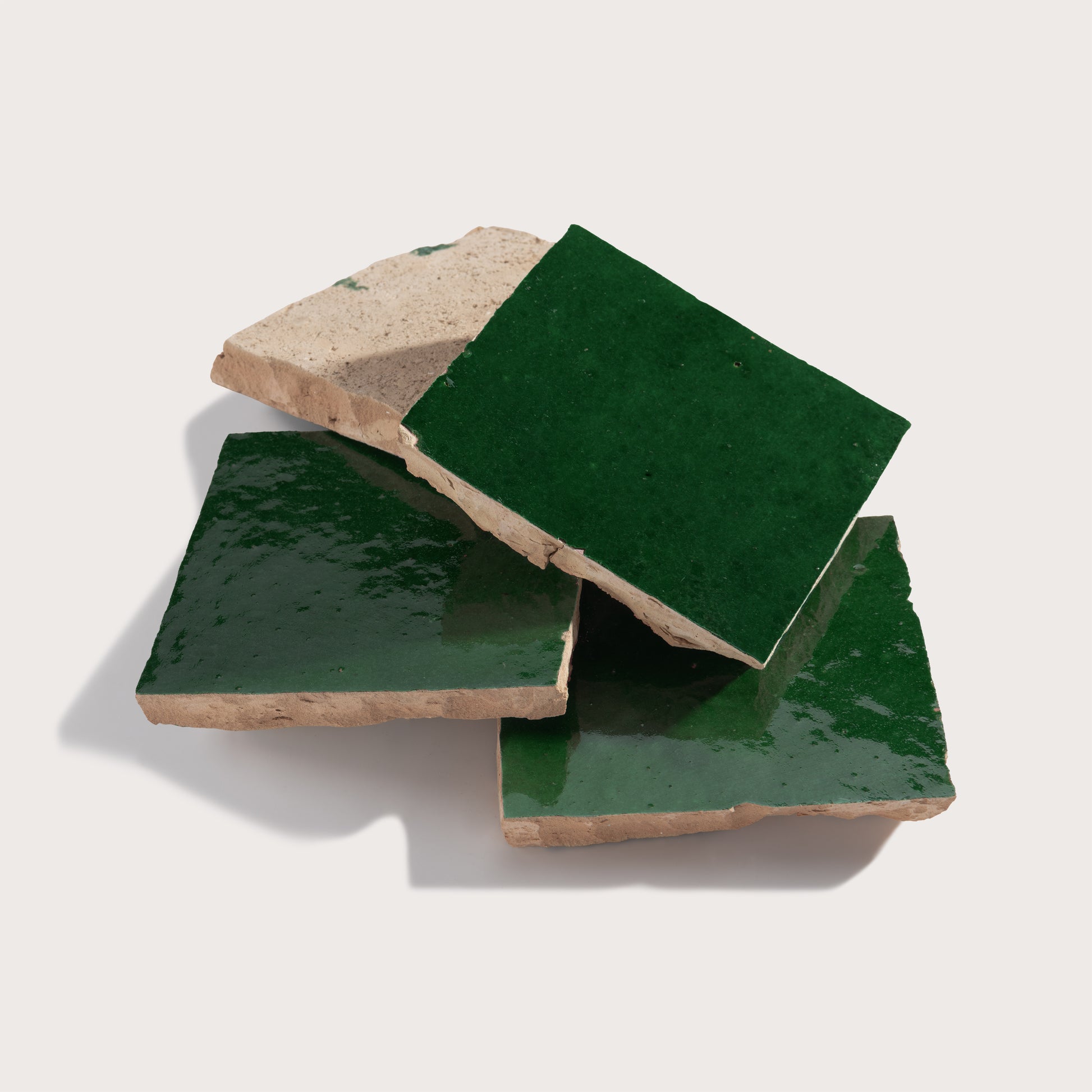 Three green zellige tiles on a white background