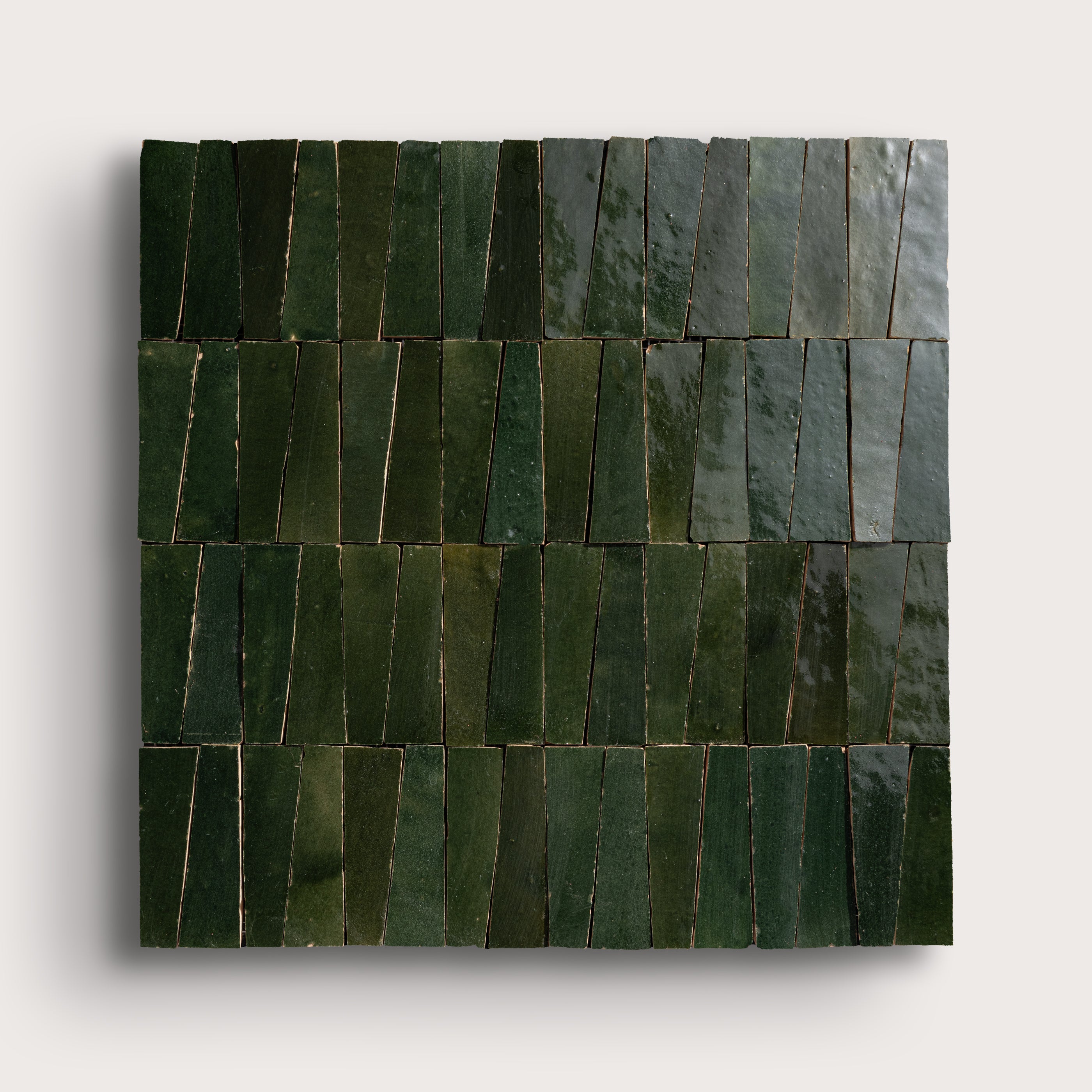 Green zellige tiles arranged in a geometric pattern on a white background