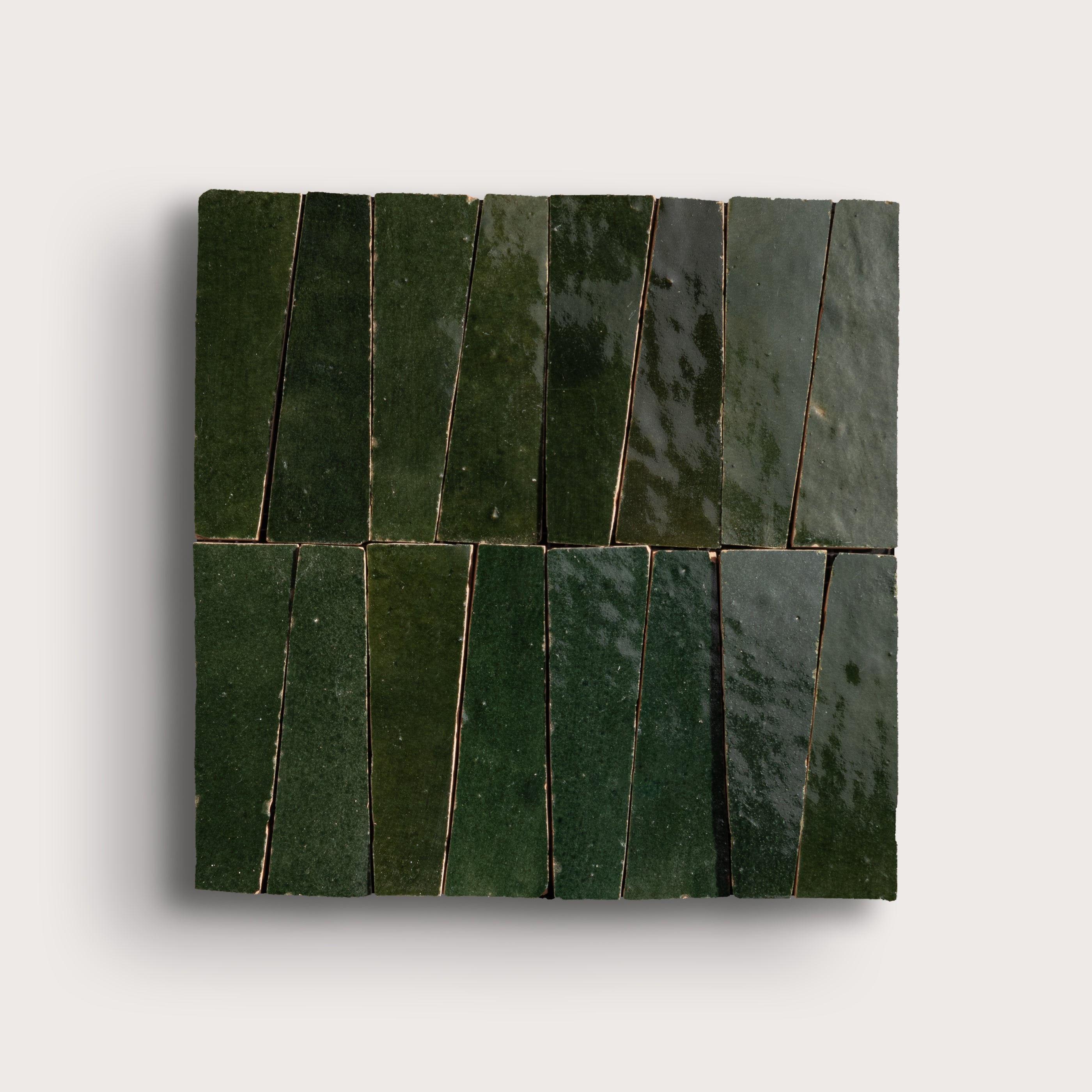 Green zellige tiles arranged in a geometric pattern on a white background