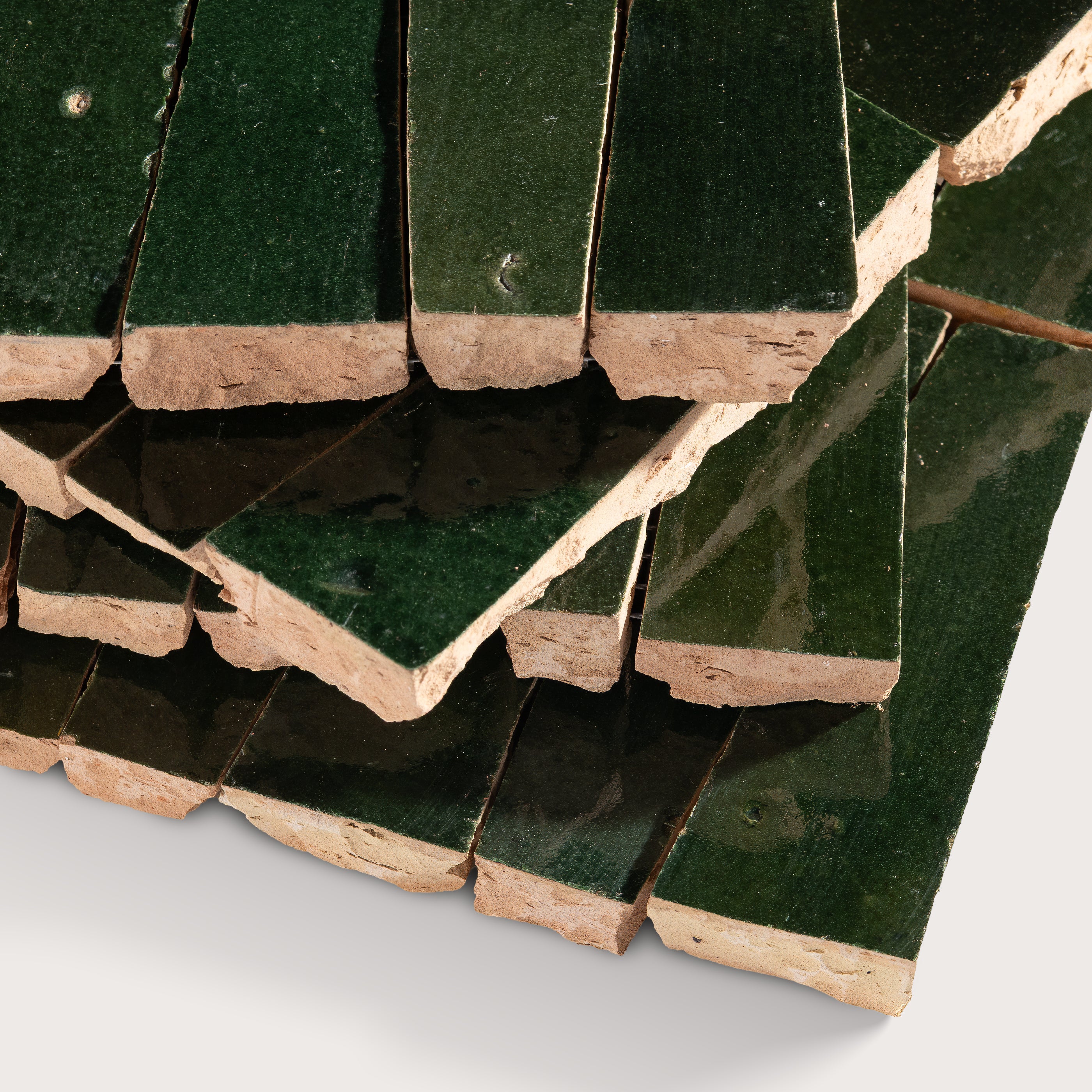 Close-up of green zellige tiles with a white background