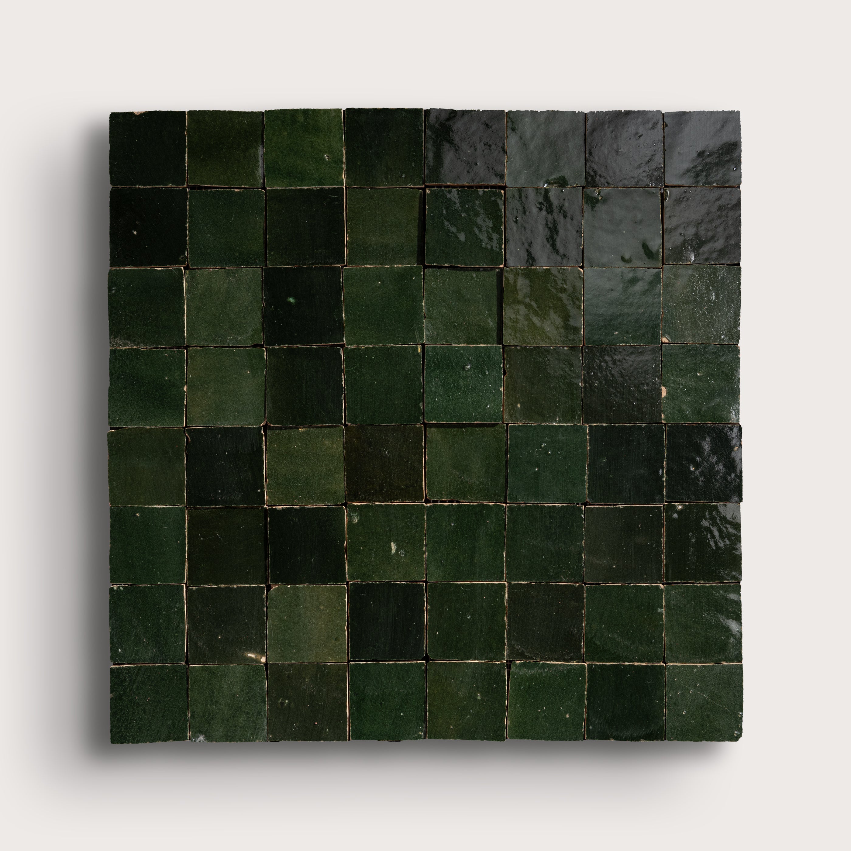 Square tile with green pattern on a white background