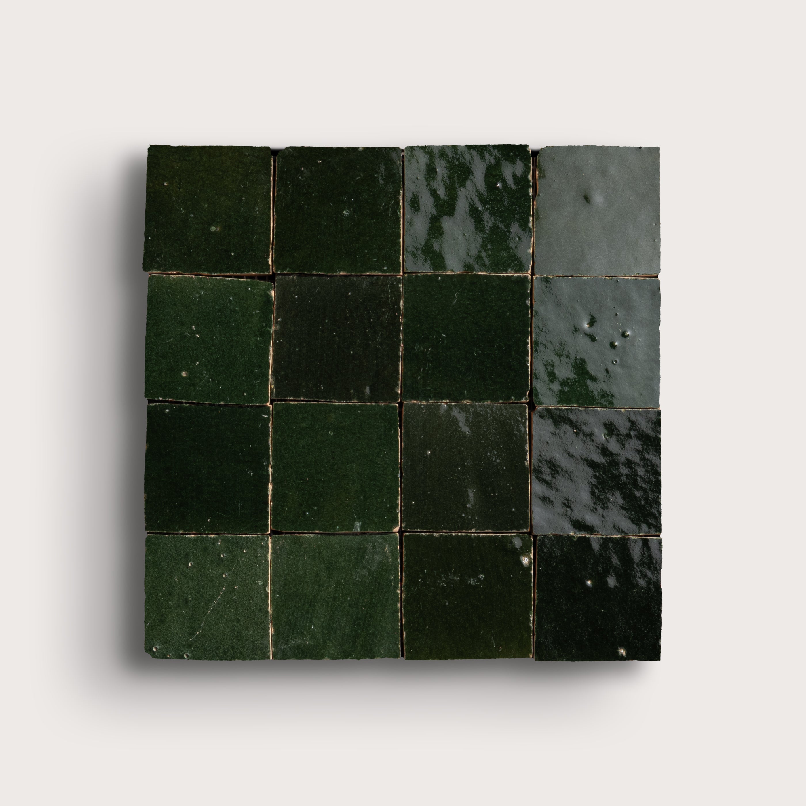 Square tile with green square pattern on a light gray background