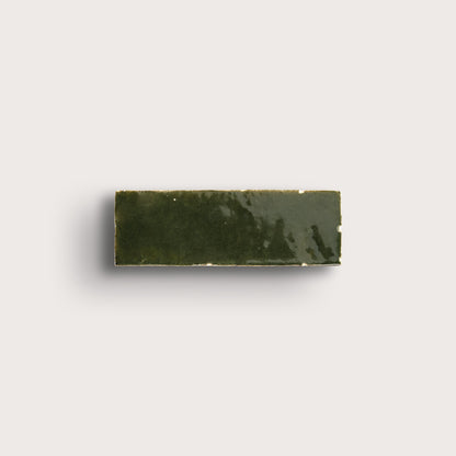 Rectangular zellige green tile on a light gray background
