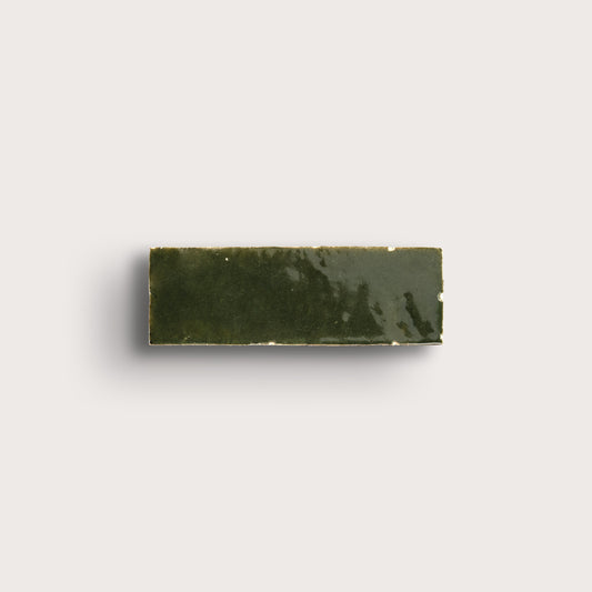 Rectangular zellige green tile on a light gray background
