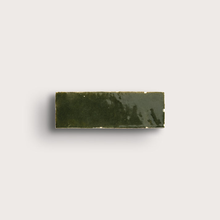 Rectangular zellige green tile on a light gray background