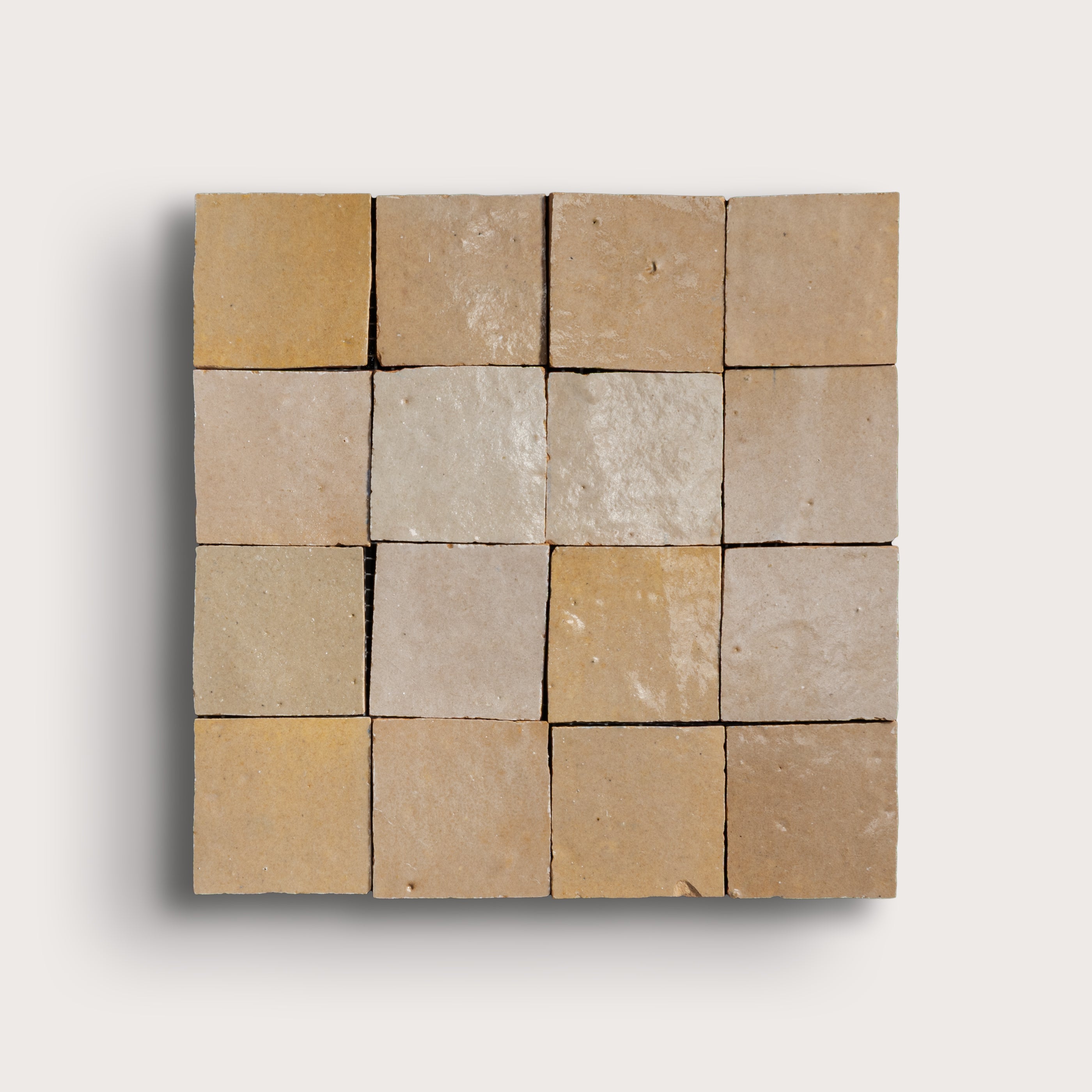 Square arrangement of stone tiles in various shades of brown on a light gray background