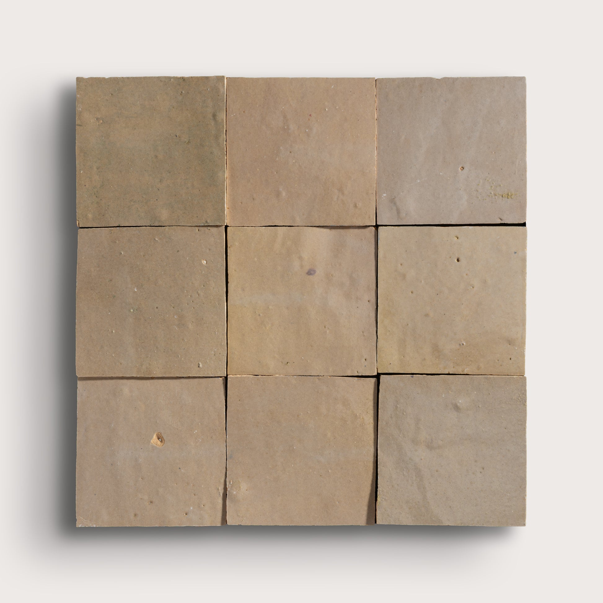 Nine square zellige tiles in various shades of brown on a white background