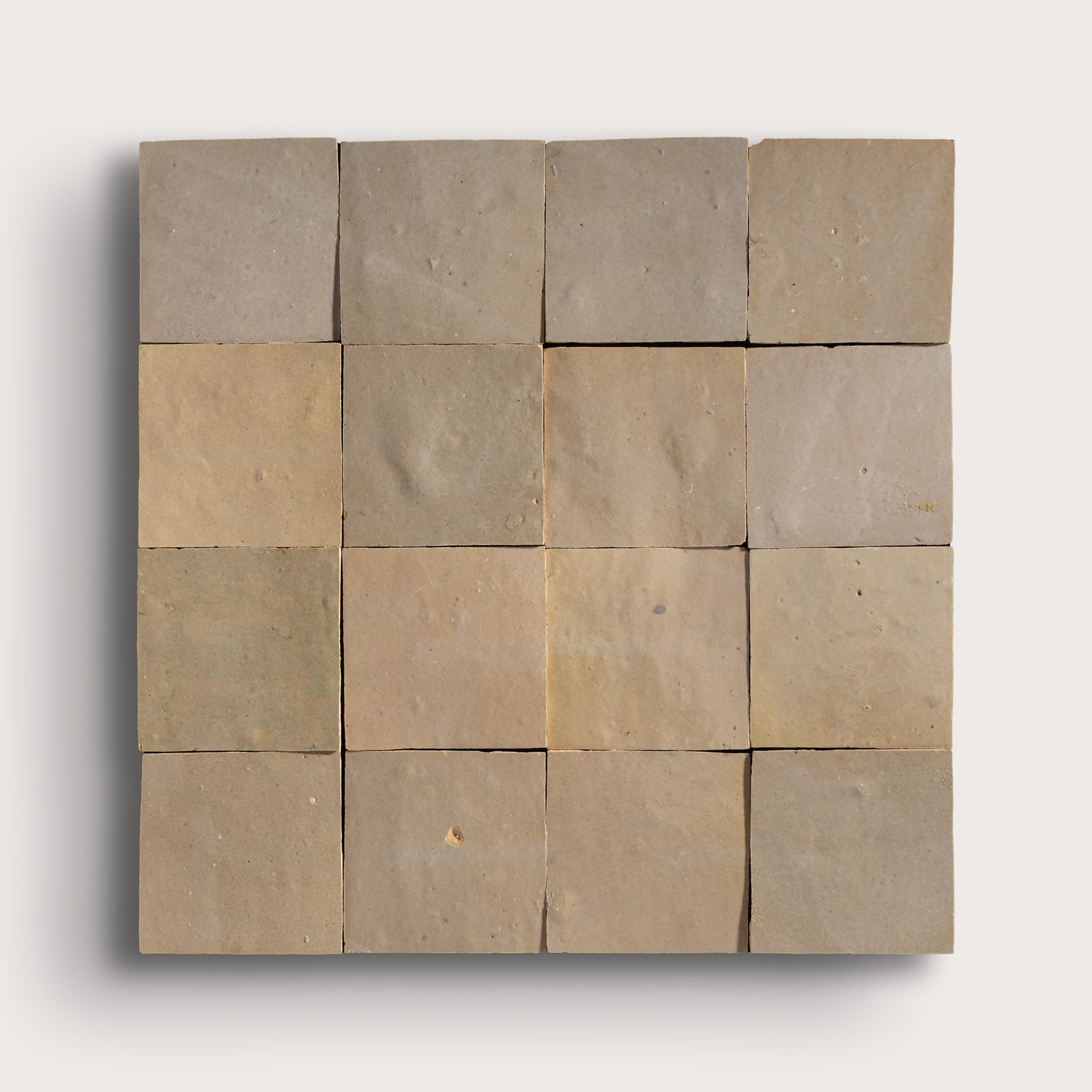 Square arrangement of zellige tiles in various shades of brown on a white background