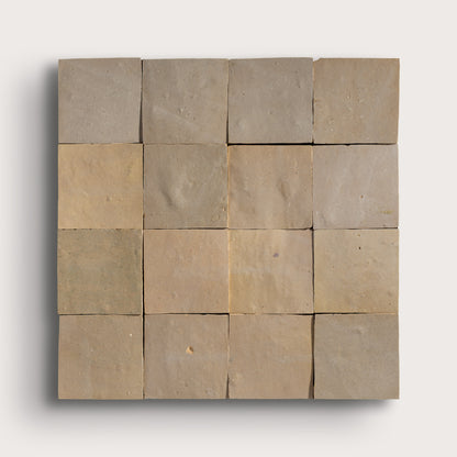 Square arrangement of zellige tiles in various shades of brown on a white background