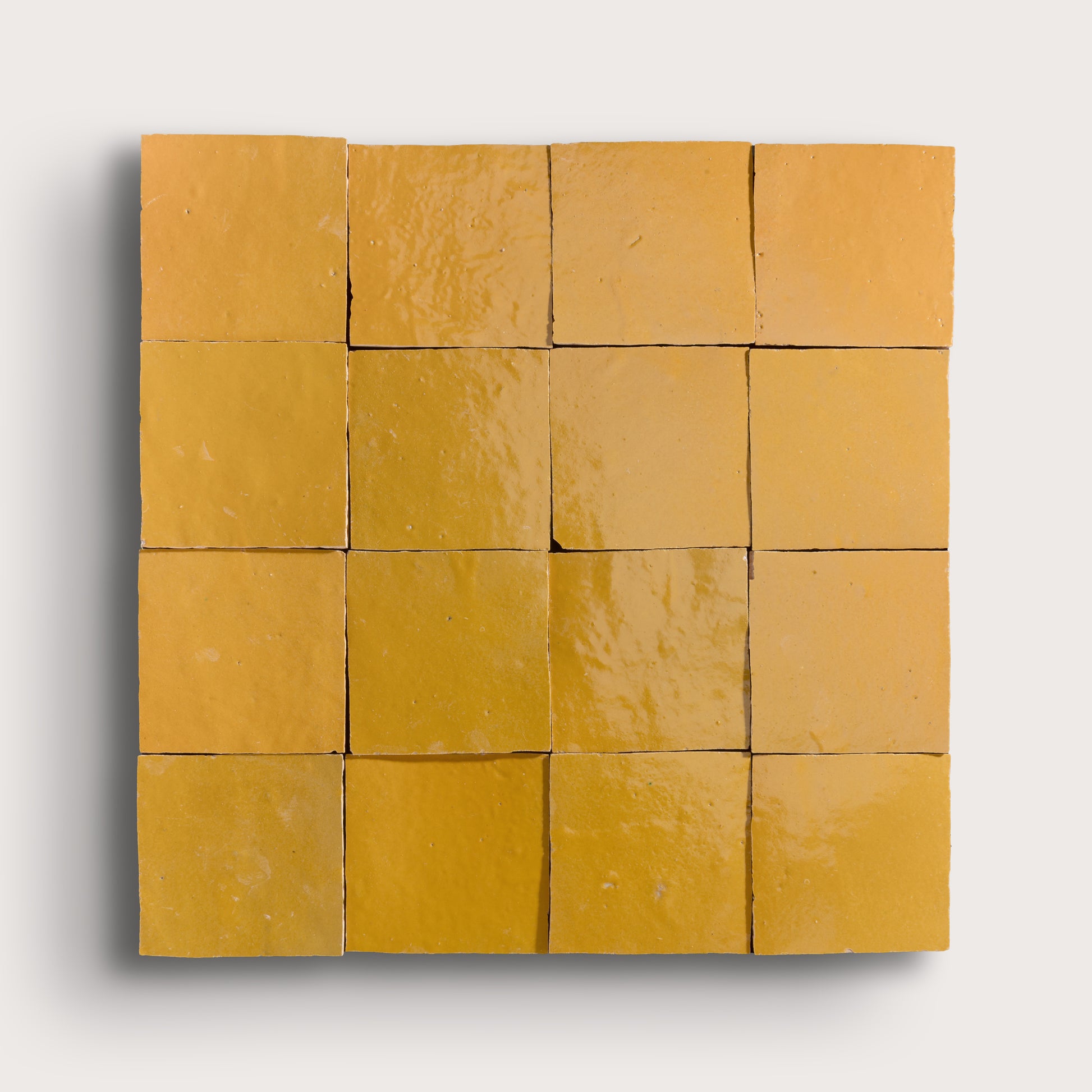 Grid of yellow square zellige tiles on a white background