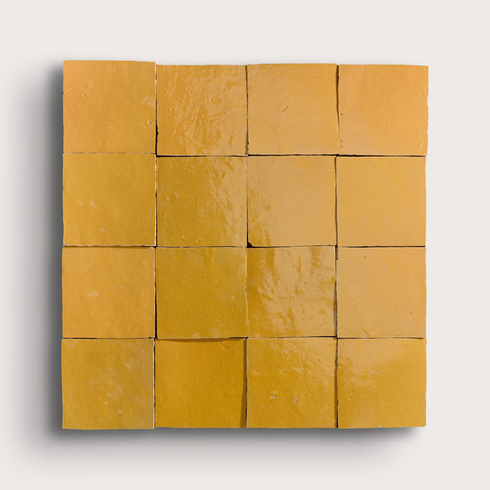 Grid of yellow square zellige tiles on a white background
